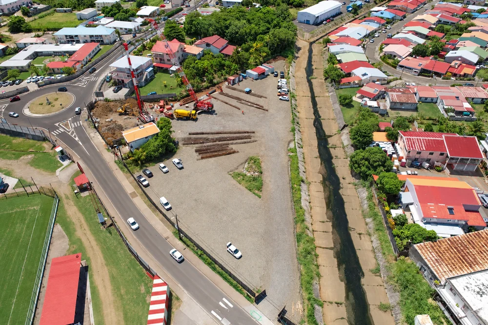 Vue aérienne du chantier du stade du Robert, avec les engins, les accès et le quartier environnant en Martinique